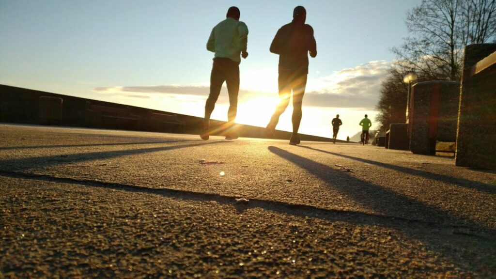 朝日を浴びながらランニングをする男性