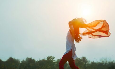 夕日に髪をなびかせる女性